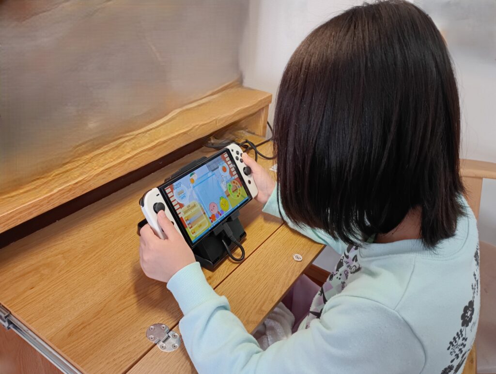 Nintendo Switch用スタンドを使って正しい姿勢でゲームをしている子どもの様子
